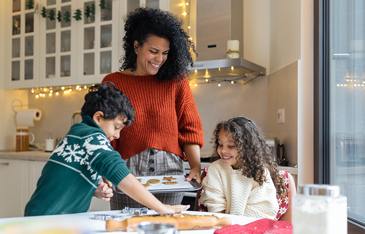 Woman making cookies with two children